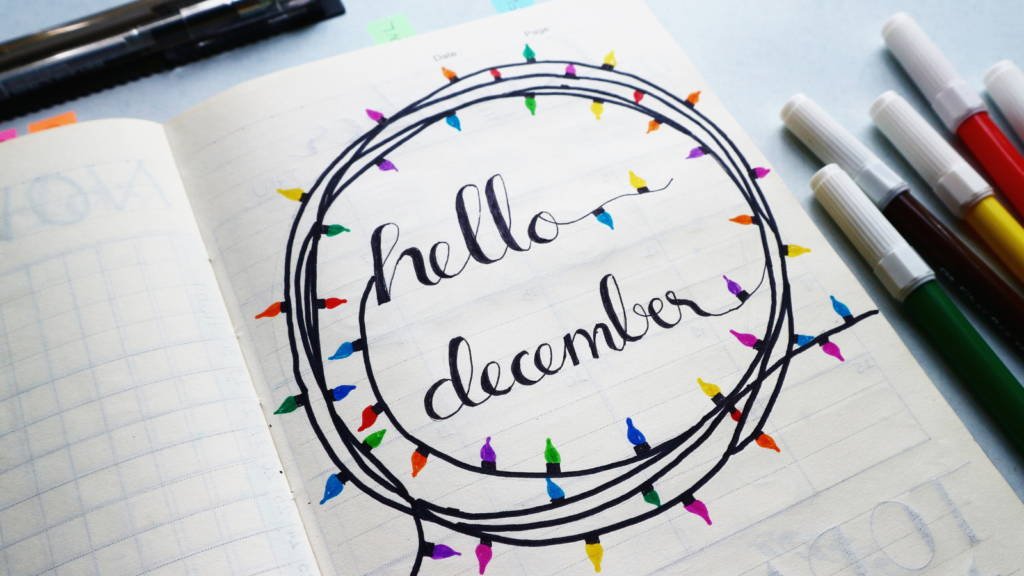 "hello december" writen in the middle of a wreath of colorful lights drawn with pen