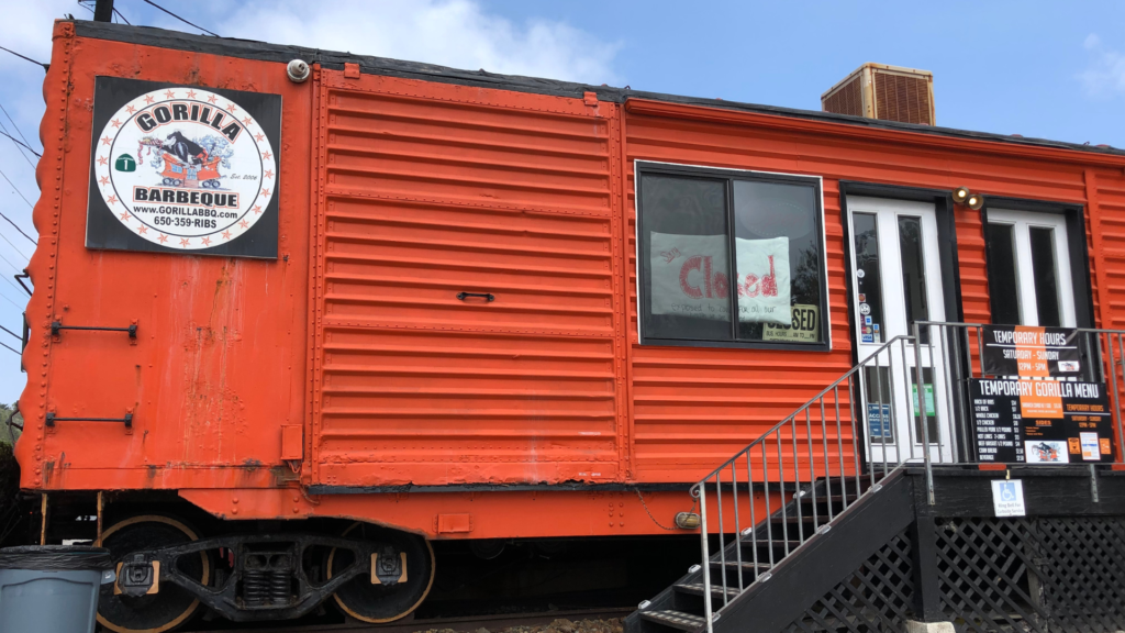 red train car that has a bbq place in it